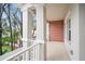 View of the balcony with white railings and columns plus an exposed brick wall at 4511 S Manhattan Ave # 18, Tampa, FL 33611