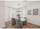 Elegant dining room with glass table, gray chairs, wood floors and abundant natural light at 4754 Easter Ter, North Port, FL 34286