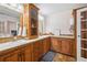 The bathroom features a double sink vanity, a tower cabinet, and wood look floors at 4946 Blanco Dr, Zephyrhills, FL 33541