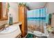 Well-lit bathroom featuring a wooden vanity and a shower with a beach-themed shower curtain at 4946 Blanco Dr, Zephyrhills, FL 33541
