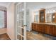 The bathroom features a double vanity with a tower cabinet, and a door leading to the main bedroom at 4946 Blanco Dr, Zephyrhills, FL 33541