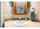 Close-up shot of a bathroom sink with a wooden-framed mirror and beige countertops at 4946 Blanco Dr, Zephyrhills, FL 33541