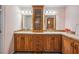 The bathroom features a double sink vanity, a tower cabinet, and wood look floors at 4946 Blanco Dr, Zephyrhills, FL 33541