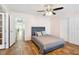 Bedroom with wood floors, grey headboard, a ceiling fan, and two windows at 4946 Blanco Dr, Zephyrhills, FL 33541