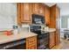 Kitchen featuring granite countertops, wooden cabinets, and black appliances at 4946 Blanco Dr, Zephyrhills, FL 33541