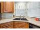 Close up on a kitchen sink with granite countertops, wood cabinets, and a window view at 4946 Blanco Dr, Zephyrhills, FL 33541