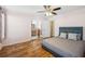 This main bedroom features wood floors, a ceiling fan, and ensuite bathroom access through french doors at 4946 Blanco Dr, Zephyrhills, FL 33541