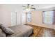 A main bedroom showcases wood floors, a ceiling fan, two windows, and closet with sliding doors at 4946 Blanco Dr, Zephyrhills, FL 33541