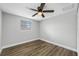 Light bedroom features a ceiling fan, window, and hardwood floors at 6232 Jackson St, New Port Richey, FL 34653