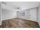 Bright bedroom featuring wood-look flooring, a ceiling fan and a window providing natural light at 6232 Jackson St, New Port Richey, FL 34653