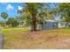 Charming single-story home with a blue exterior, lush lawn, and mature trees at 6232 Jackson St, New Port Richey, FL 34653