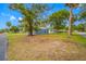 Charming single-story home with a blue exterior, lush lawn, and mature trees at 6232 Jackson St, New Port Richey, FL 34653