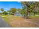 Charming single-story home with a blue exterior, lush lawn, and mature trees at 6232 Jackson St, New Port Richey, FL 34653
