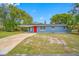 A charming blue house with a vibrant red door and a spacious front yard at 6232 Jackson St, New Port Richey, FL 34653