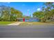 A charming blue house with a vibrant red door and a spacious front yard at 6232 Jackson St, New Port Richey, FL 34653