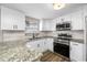 Bright kitchen features granite countertops, stainless steel appliances and white cabinets at 6232 Jackson St, New Port Richey, FL 34653