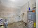 Unfinished utility room with concrete floors, cement block walls and a hot water heater at 6232 Jackson St, New Port Richey, FL 34653