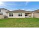 A backyard view featuring a covered patio and a well-maintained lawn at 7608 Broad Pointe Dr, Zephyrhills, FL 33540