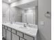 Bright bathroom with double sinks, large mirror, and shower/tub combination at 7608 Broad Pointe Dr, Zephyrhills, FL 33540