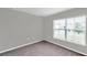 An empty bedroom with carpet and a large window providing plenty of natural light at 7608 Broad Pointe Dr, Zephyrhills, FL 33540