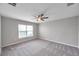 Carpeted bedroom featuring a ceiling fan and a large window at 7608 Broad Pointe Dr, Zephyrhills, FL 33540