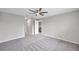 A well-lit bedroom with carpet, ceiling fan and a doorway leading to the kitchen at 7608 Broad Pointe Dr, Zephyrhills, FL 33540