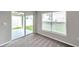 Bedroom with large windows and sliding door access to the backyard at 7608 Broad Pointe Dr, Zephyrhills, FL 33540