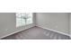 A bright bedroom with neutral walls, plush carpet, and a window that allows for plenty of natural light at 7608 Broad Pointe Dr, Zephyrhills, FL 33540