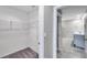 A walk-in closet featuring built-in shelving for organized storage, leading to a bathroom at 7608 Broad Pointe Dr, Zephyrhills, FL 33540