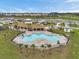 Aerial view of the community pool with lounge chairs and covered outdoor space in a residential neighborhood at 7608 Broad Pointe Dr, Zephyrhills, FL 33540