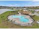 Aerial view features a community pool with inviting lounge areas, lush landscaping, and access to covered recreational spaces at 7608 Broad Pointe Dr, Zephyrhills, FL 33540