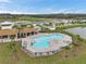 Aerial view of the community pool with lounge chairs and covered outdoor space in a residential neighborhood at 7608 Broad Pointe Dr, Zephyrhills, FL 33540