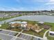 Aerial view of community pool, clubhouse, playground, parking and lake in a well-maintained neighborhood on a sunny day at 7608 Broad Pointe Dr, Zephyrhills, FL 33540
