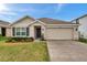 Charming single-story home with a well-manicured lawn, tidy landscaping, and an attached two-car garage at 7608 Broad Pointe Dr, Zephyrhills, FL 33540