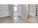 Inviting hallway featuring neutral tile floors, leading to a bathroom and a bedroom with an abundance of natural light at 7608 Broad Pointe Dr, Zephyrhills, FL 33540