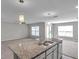 Open floor plan with kitchen island, modern pendant lighting, and a view into the spacious living area at 7608 Broad Pointe Dr, Zephyrhills, FL 33540