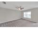 Spacious carpeted main bedroom with a ceiling fan and a window for plenty of natural light at 7608 Broad Pointe Dr, Zephyrhills, FL 33540