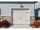 Attached garage door with stone accents and manicured landscaping at 7782 93Rd N St, Seminole, FL 33777