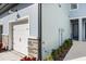 Attached garage door with stone accents, landscaping, and exterior of townhome at 7782 93Rd N St, Seminole, FL 33777