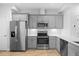 Modern kitchen features gray cabinets, stainless steel appliances, and wood-look flooring at 7782 93Rd N St, Seminole, FL 33777