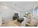 Bright living room with neutral tones, wood-look tile floors, and sliding glass doors to the outdoor space at 7782 93Rd N St, Seminole, FL 33777