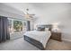 Bright main bedroom features a ceiling fan, neutral carpet, and a large window with tree views at 7782 93Rd N St, Seminole, FL 33777