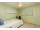 Cozy bedroom featuring a ceiling fan, light green walls, and neutral tile flooring at 800 71St N Ave # 8, St Petersburg, FL 33702