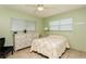 Bright bedroom features a ceiling fan, updated windows, and charming, white furniture with updated lighting at 800 71St N Ave # 8, St Petersburg, FL 33702