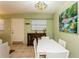 Dining room with white table and chairs, cabinet, and decorative lighting fixture and artwork at 800 71St N Ave # 8, St Petersburg, FL 33702