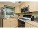 Cozy kitchen with stainless steel microwave above gas range and light wood cabinets at 800 71St N Ave # 8, St Petersburg, FL 33702