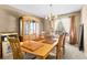 Elegant dining room featuring a wooden table set for six, complemented by a stylish china cabinet and natural light at 8555 140Th St, Seminole, FL 33776