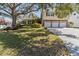 Charming two-story home featuring a manicured lawn, mature trees, and a three-car garage at 8555 140Th St, Seminole, FL 33776