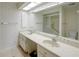 Bathroom featuring double sinks, a large mirror, and a walk-in shower at 860 Glen More Ct # B, Palm Harbor, FL 34684
