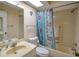 Bathroom featuring a vanity sink, toilet, and shower/tub combination with floral curtains at 860 Glen More Ct # B, Palm Harbor, FL 34684